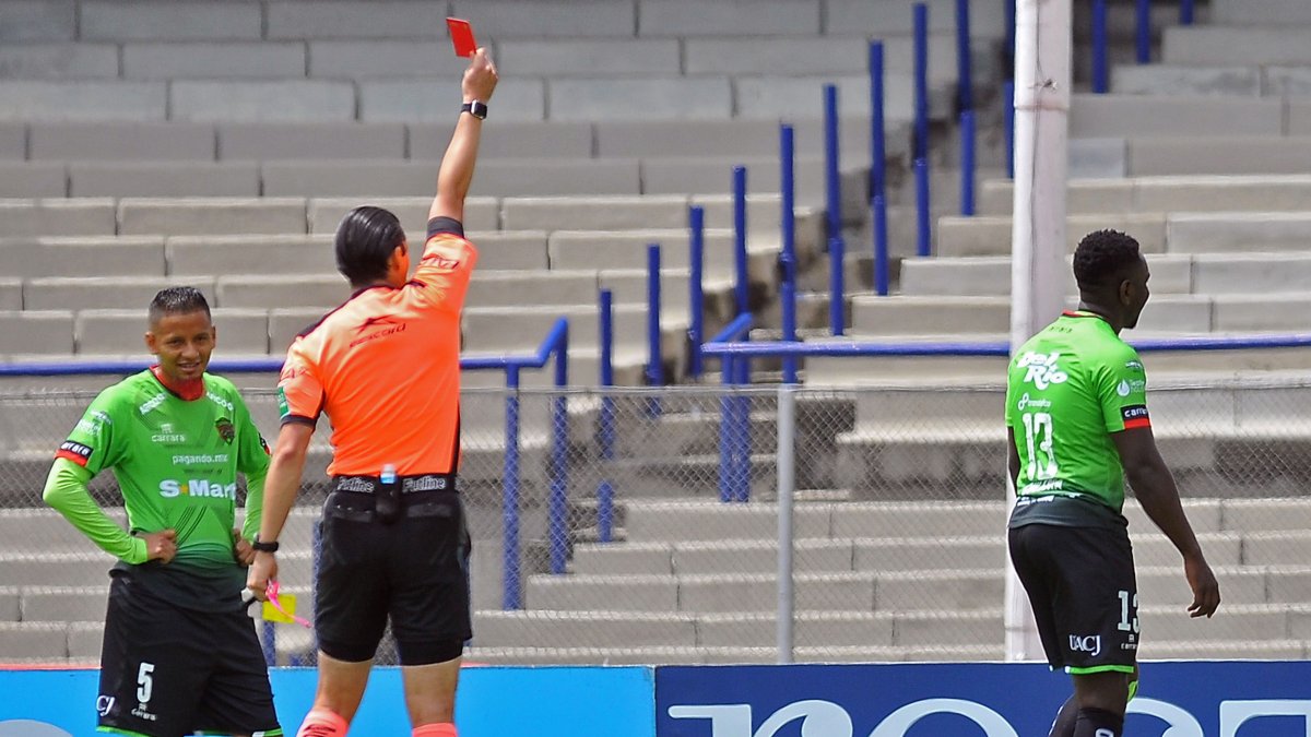 Érick Castillo (d) se va del campo, mientras Jefferson Intriago observa al juez que le muestra la tarjeta roja