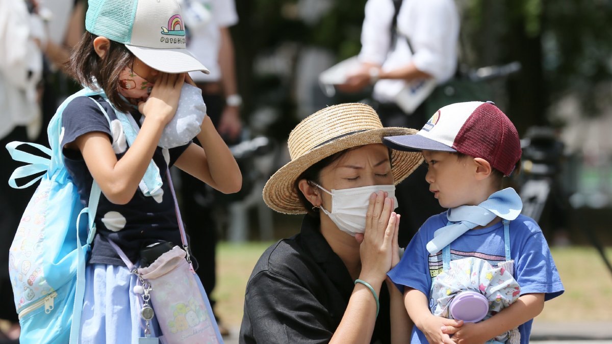 Una familia ofrece una oración  por las víctimas de la bomba atómica en el Parque Hipocentro de Nagasaki, donde este domingo se recordó el 75 aniversario del bombardeo atómico