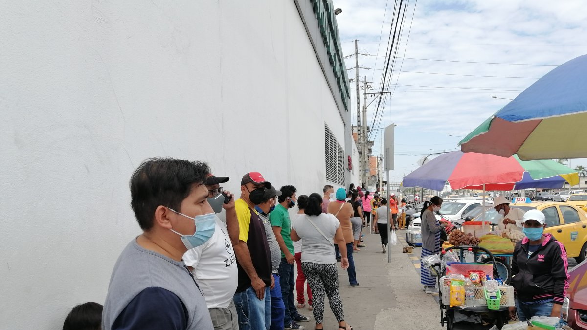 En Valdivia, al sur de Guayaquil, las personas hacen fila sin mantener el distanciamiento físico.