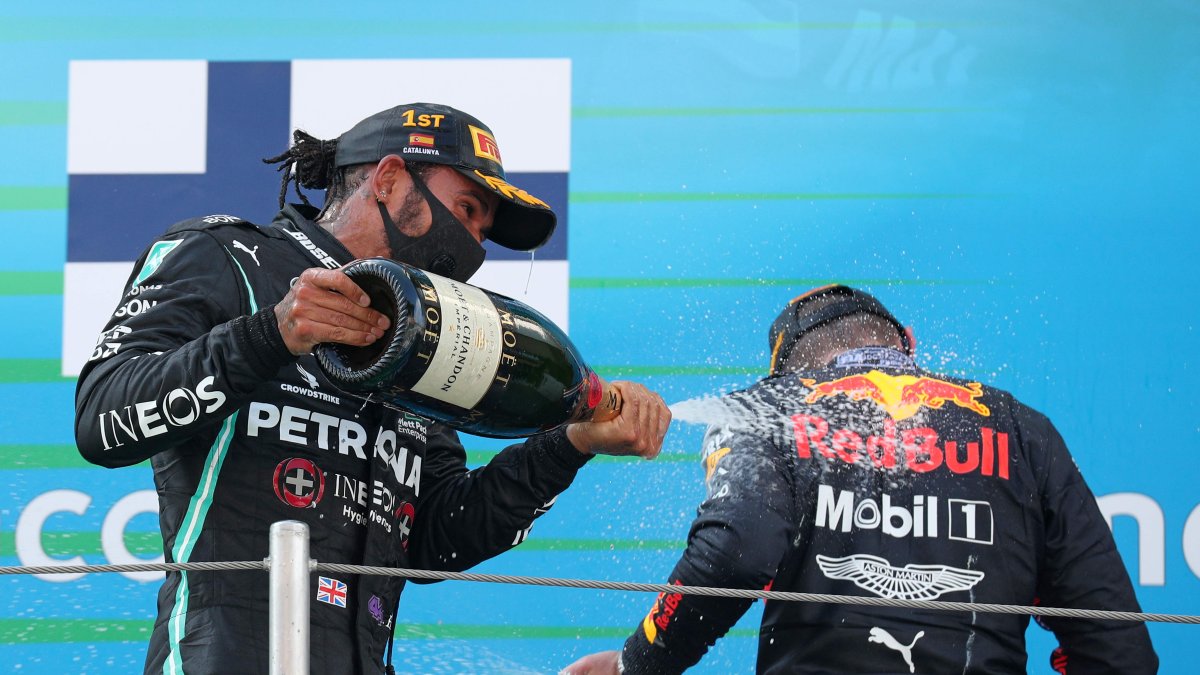 Lewis Hamilton (i) celebra una nueva victoria junto a su escolta, Max Verstappen.
