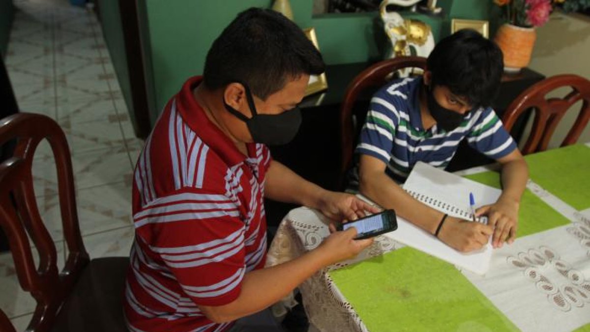 Humberto Torres apoya a su hijo Jhonatan en sus clases virtuales.