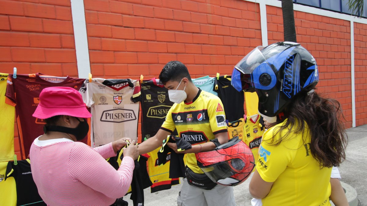 Silvia Adrián (i) realizó una de las pocas ventas del día a Kevin Oviedo (c), quien acudió a la avenida Barcelona.