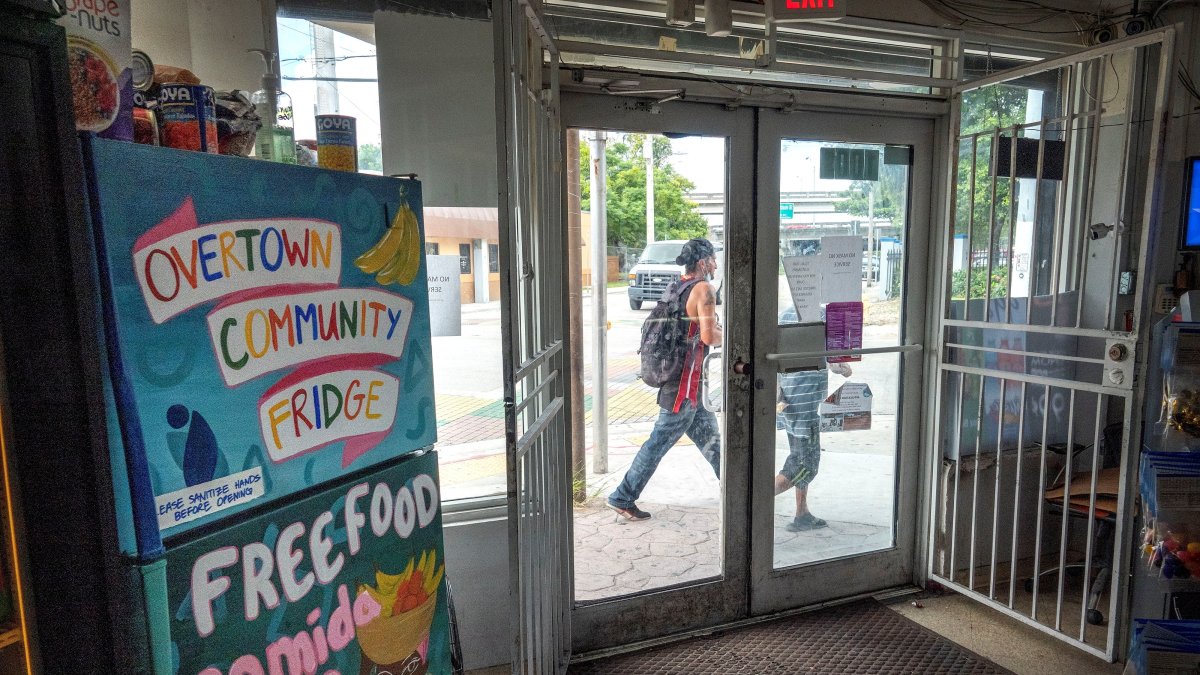 MIAMI. Dos personas caminan frente a Harba Food Store, donde está instalada una de las neveras comunitarias, en Overtown.