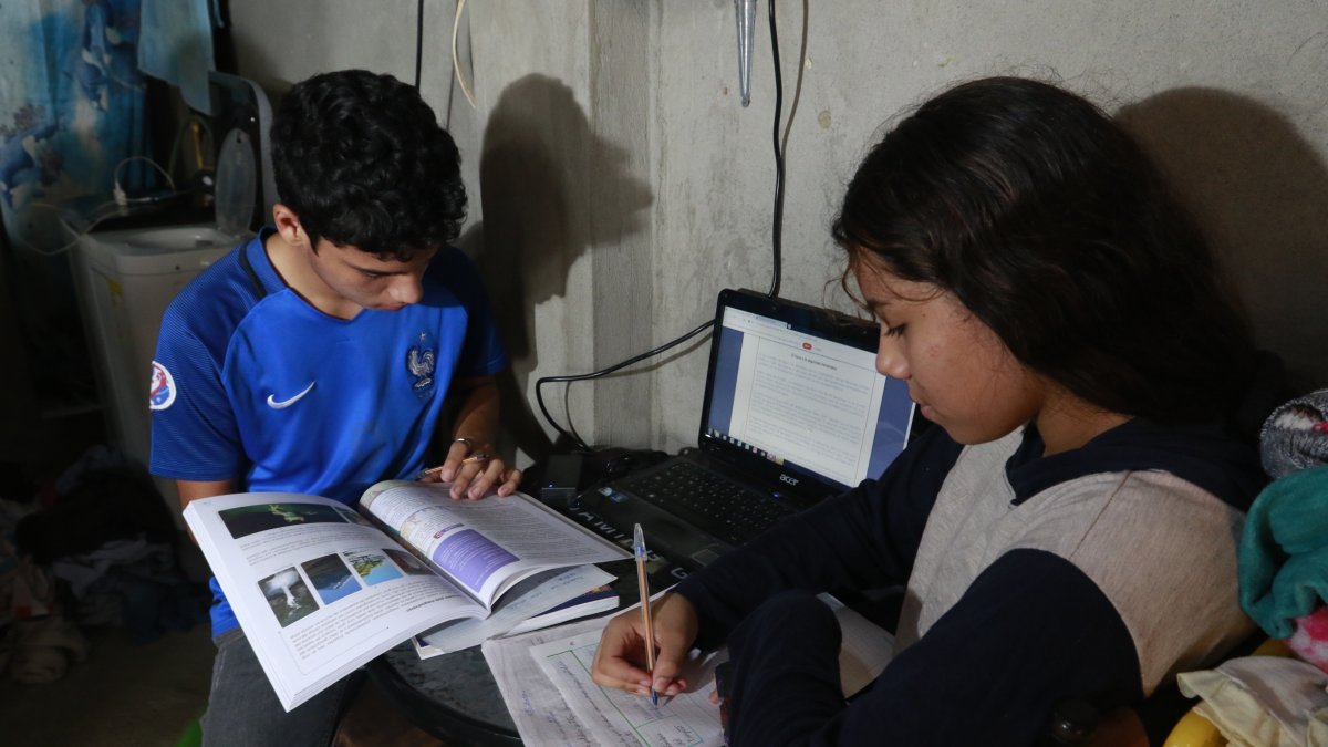 En una vivienda de la cooperativa Sergio Toral, en el norte de Guayaquil, os hermanos comparten una computadora para recibir las clases no presenciales del sistema educativo público.