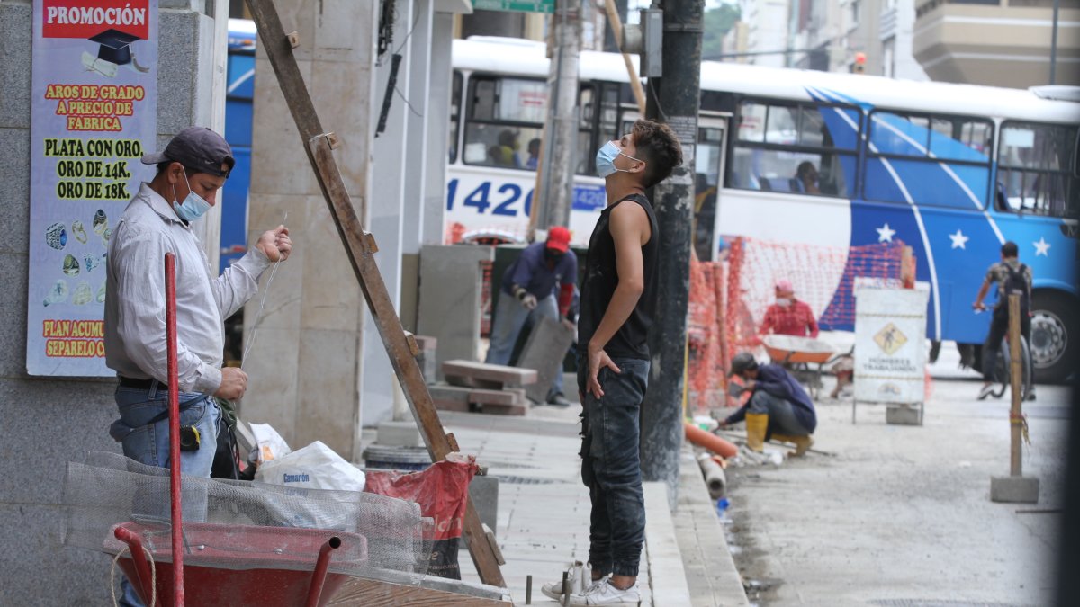 Un grupo de albañiles labora en una calle del centro de Guayaquil protegidos con mascarillas, como parte de las medidas para evitar contagios de Covid-19 en el trabajo.