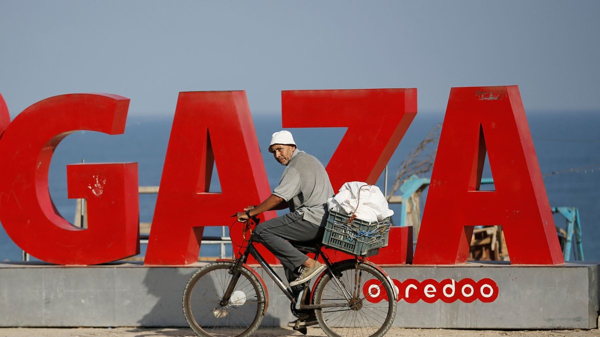 Gaza. Un palestino se traslada en bicicleta cerca de la playa.
