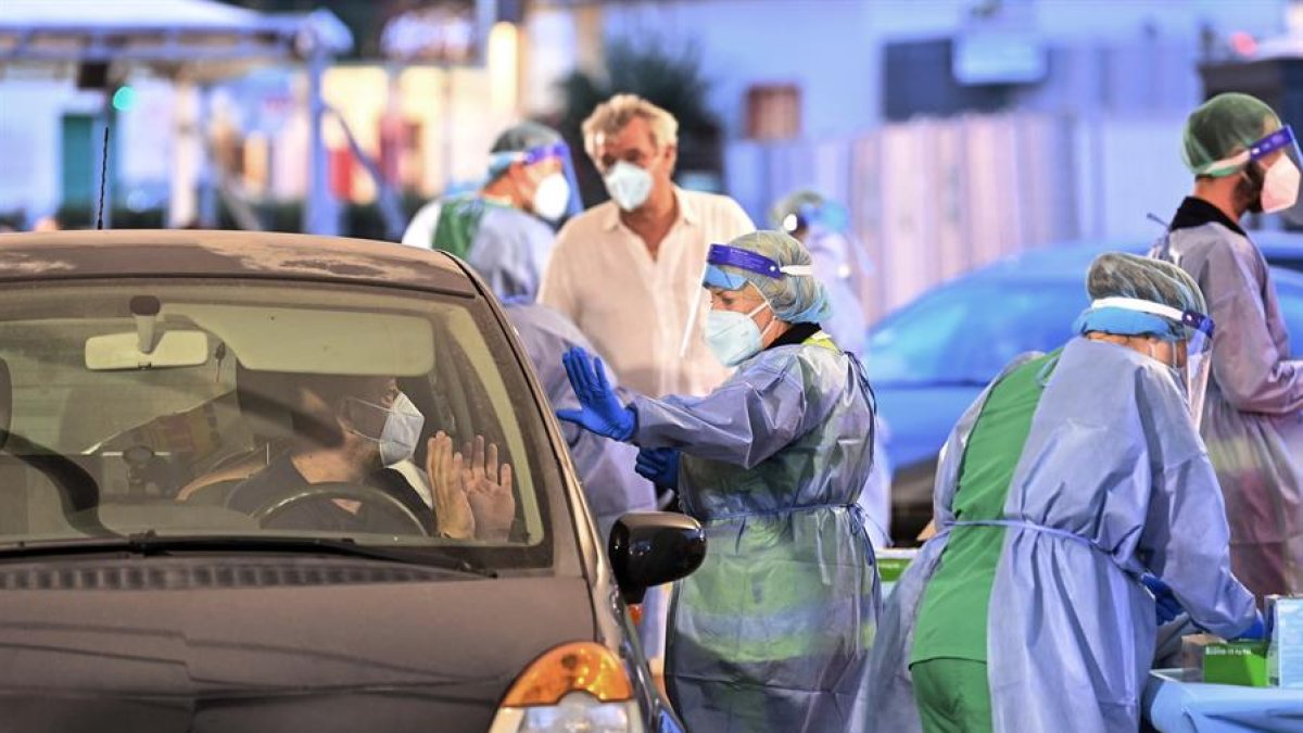 Un médico realiza pruebas de hisopado a los pasajeros de barcos que llegan de Cerdeña, en el puerto de Civitavecchia, cerca de Roma, capital de Italia.