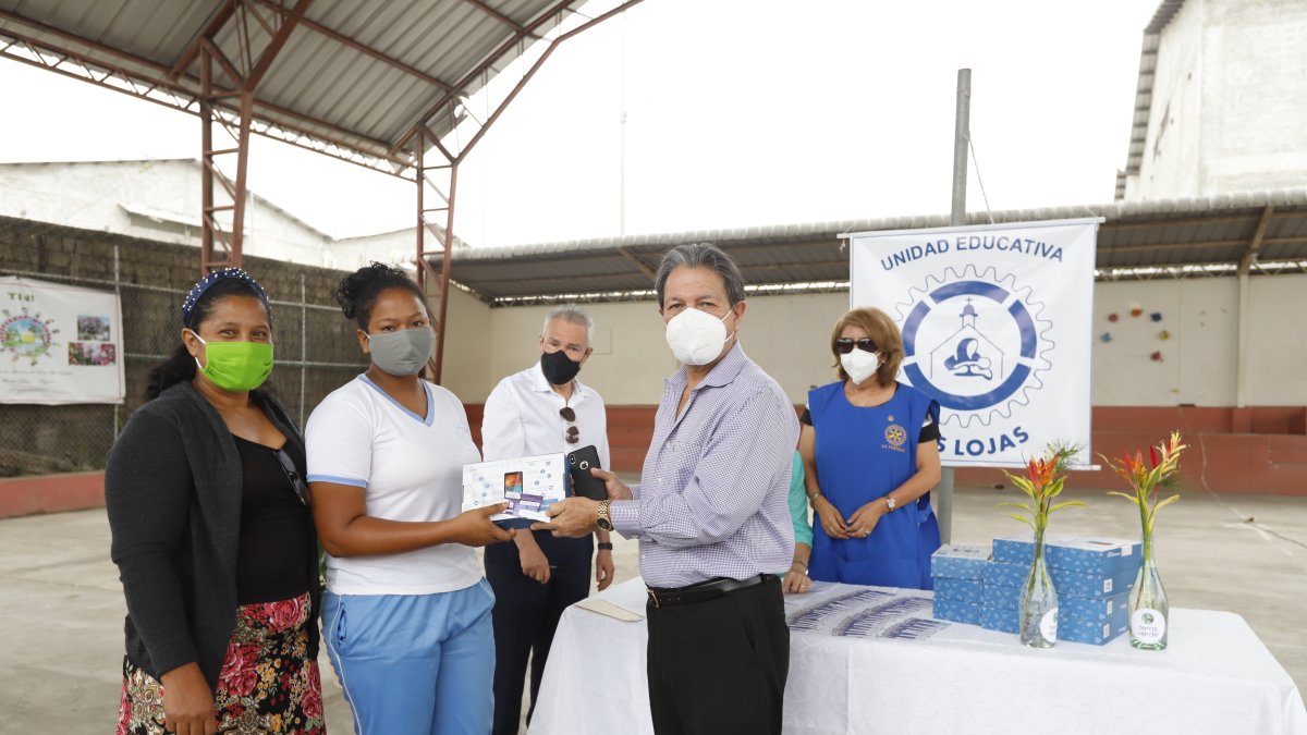 Víctor Flores, presidente del Club Rotario de La Puntilla, entrega tabletas a alumnos que por no tener dispositivo no pueden ver clases virtuales.