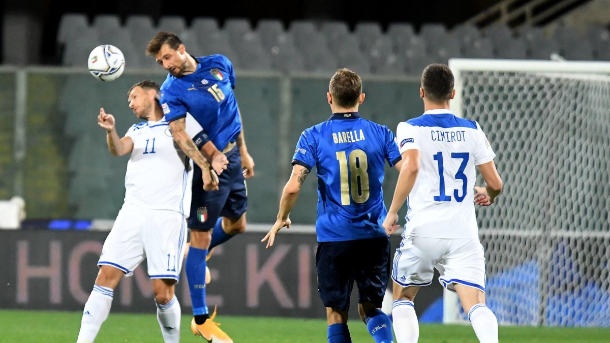 Edin Dzeko (i) pelea una pelota con el defensor Francesco Acerbi (c).