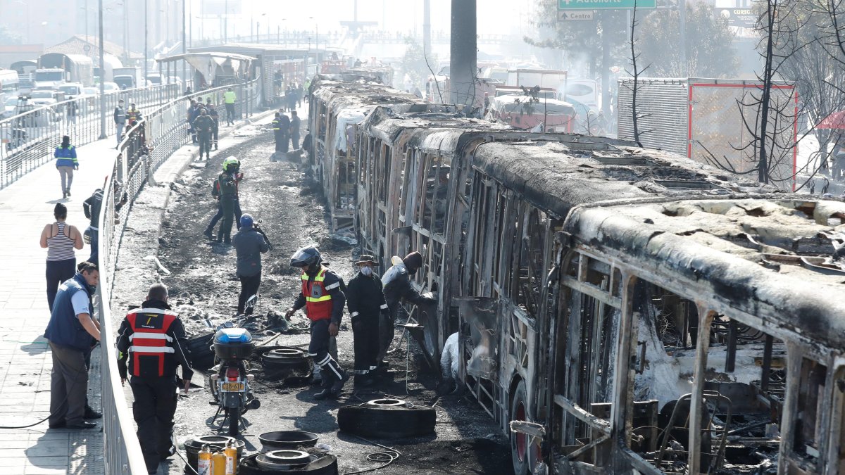 Bogotá. Funcionarios y peritos revisan los daños en los restos de buses de TransMilenio incinerados durante las protestas masivas del miércoles.