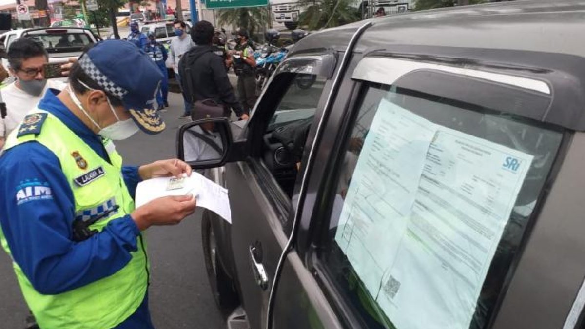 Un agente de la ATM lee un documento que le permite a un conductor circular.