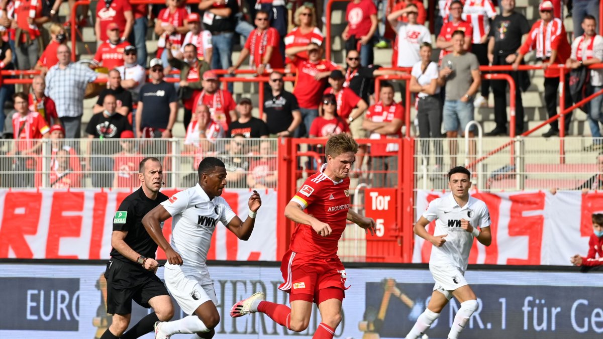 Carlos Gruezo (i), volante ecuatoriano del Augsburgo, va por la marca de un jugador del Unión Berlín.