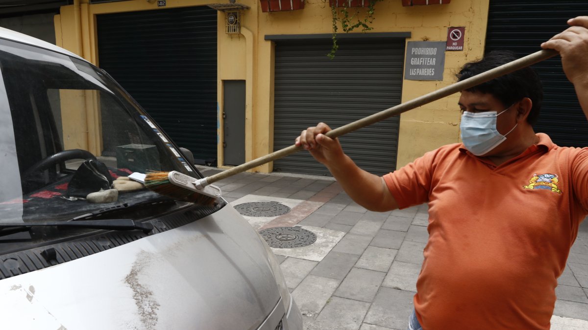 Un ciudadano de Guayaquil retira las cenizas del volcán en un barrio de Guayaquil.