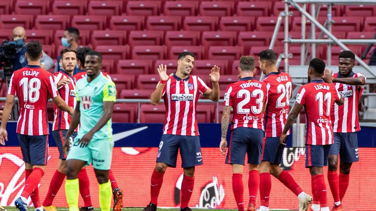 Luis Suárez (c) es felicitado por sus compañeros del Atlético de Madrid tras estrenarse como goleador.