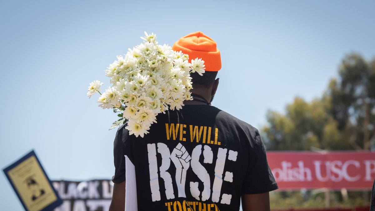 Un manifestante sostiene un ramo de flores en un pasado Black Lives Matte.