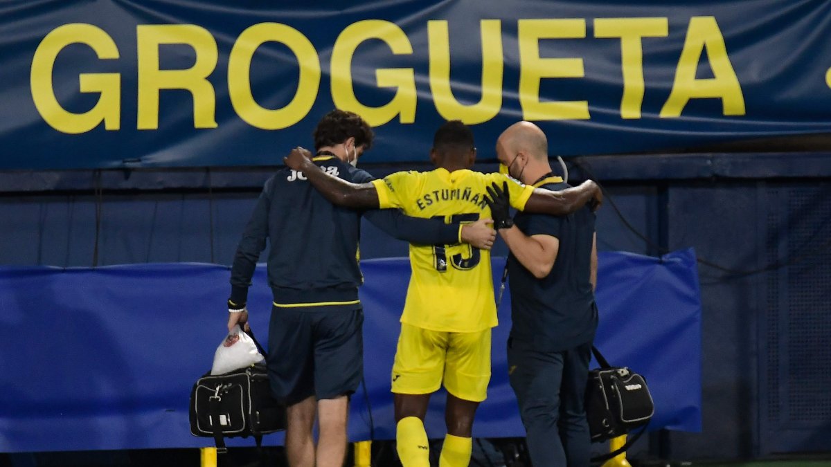 Pervis Estupinan deja la cancha ayudado por los asistentes del Villarreal, durante el partido contra el Deportivo Alaves