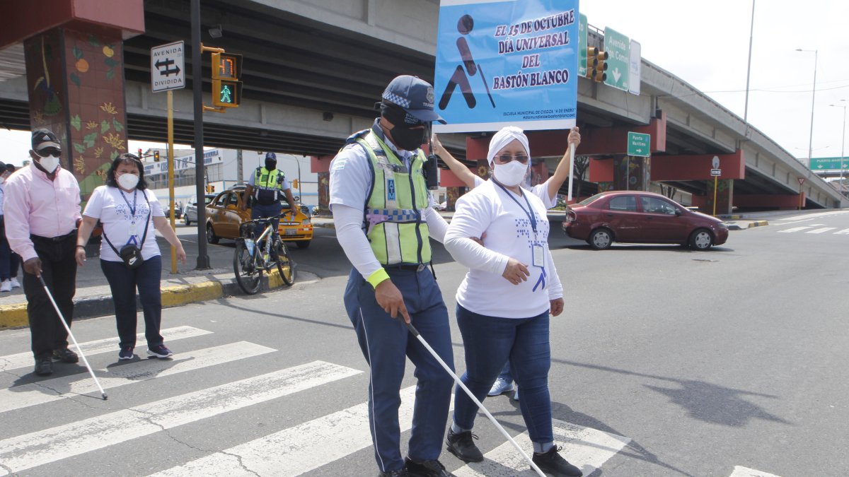 El agente de ATM, Miguel Saltos, se pone en el lugar de una persona con discapacidad al vendar sus ojos y cruzar la calle.