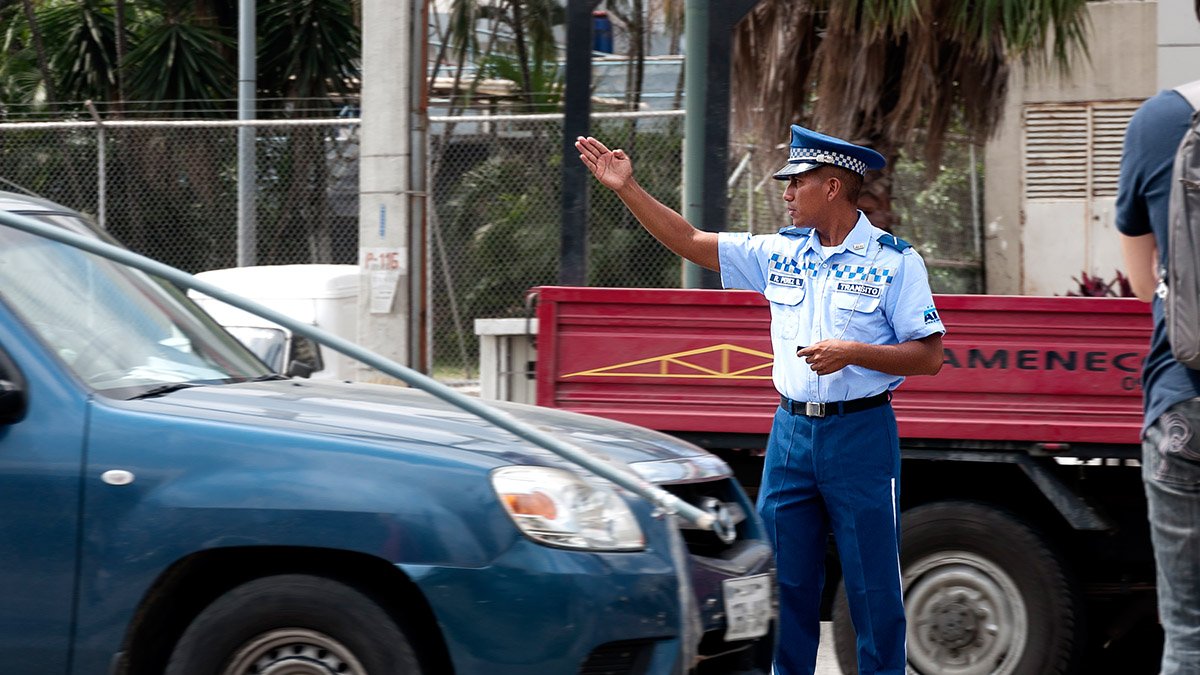 Foto referencial.- Un agente de la ATM guía el paso de los vehículos para aliviar el embotellamiento en una calles de Guayaquil.
