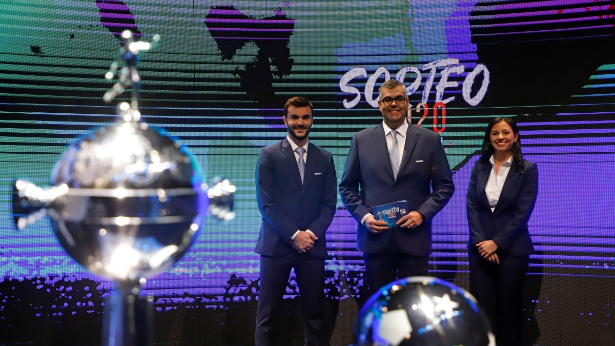 El director de competiciones de Clubes Conmebol, Frederico Nantes (c), posa junto a los trofeos de la Copa Libertadores y Sudamericana.