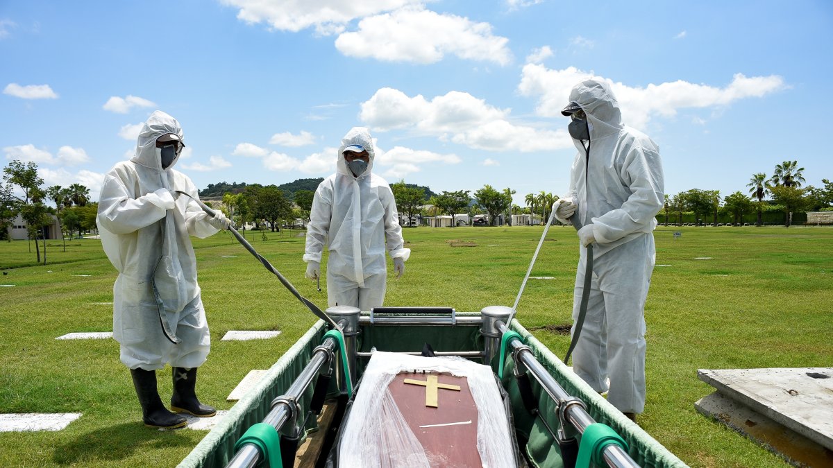 Trabajadores del cementerio Parque de la Paz entierran a un fallecido por covid-19 en el sector de la Aurora.