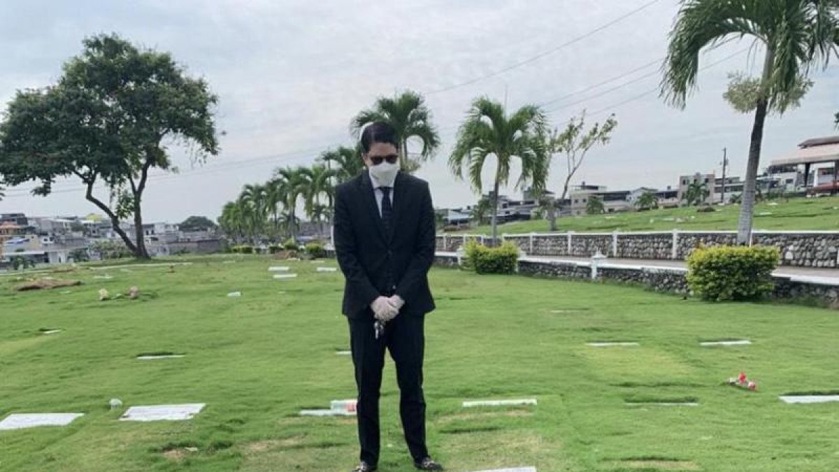 Una foto referencial de un deudo ante una tumba en un cementerio en Guayaquil.