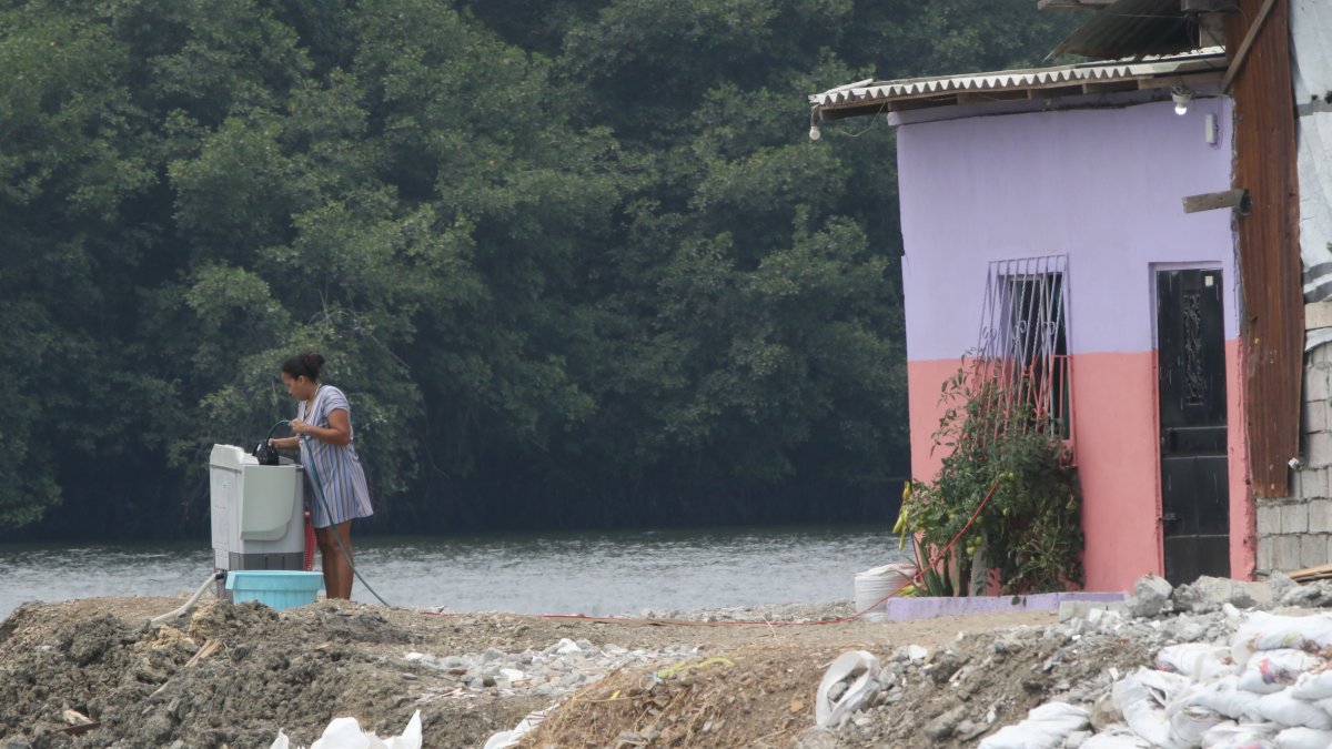 Una lavadora de ropa, junto al brazo de mar y frente al manglar que cubre la zona.