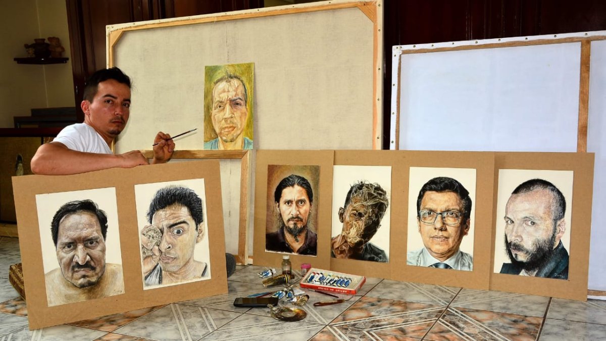 Juan Pablo Zambrano junto a algunos de los retratos que ha plasmado en la pandemia.