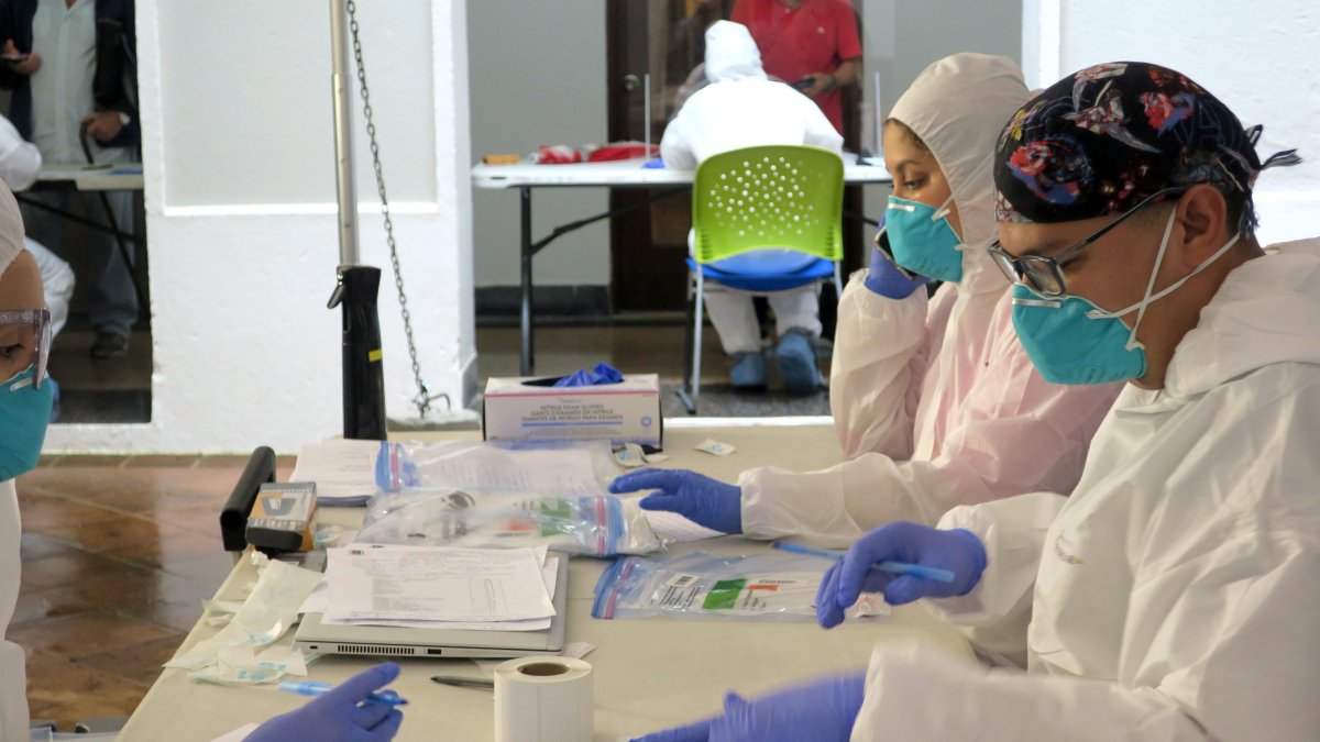 Unos técnicos de laboratorio empaquetan en bolsas de plástico las pruebas del coronavirus realizadas en San Juan.