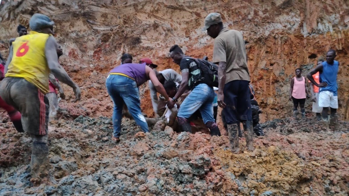 Pobladores ayudan a rescatar los cuerpos sumergidos bajo el lodo.