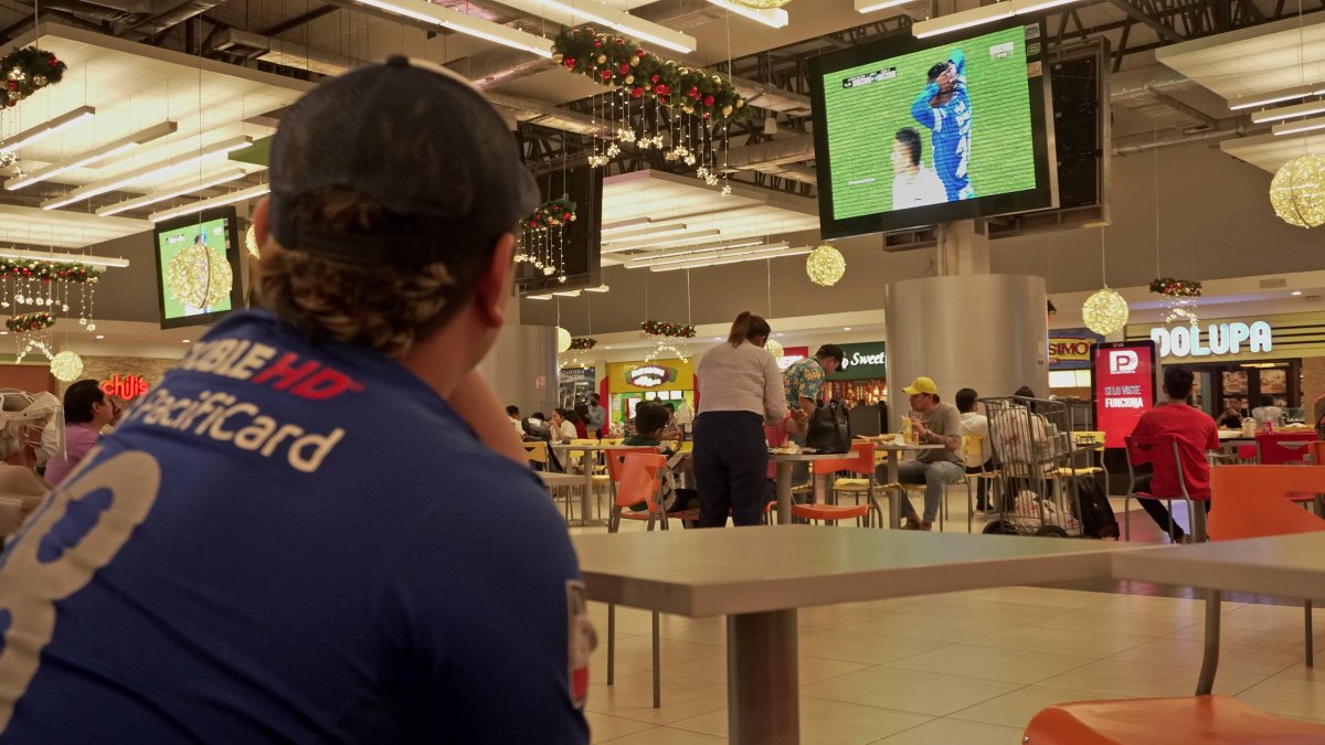 Steven Toledo trabaja en una empresa de envíos exprés. Aprovecha un tiempo libre para observar los partidos de Emelec.Lo hace en el patio de comidas de un centro comercial.