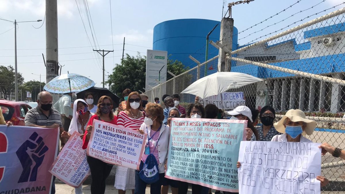Los jubilados se concentran con pancartas, bajo el sol, para protestar.