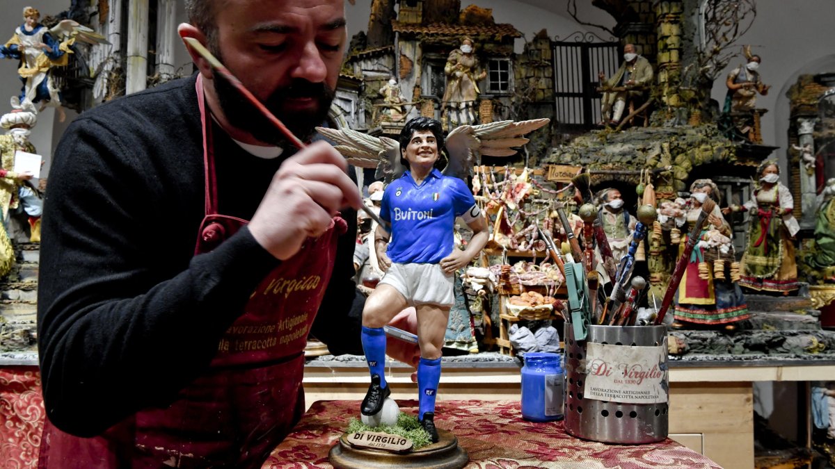 El artista italiano Genny di Vrigilio le da los últimos toques a la figura de Maradona