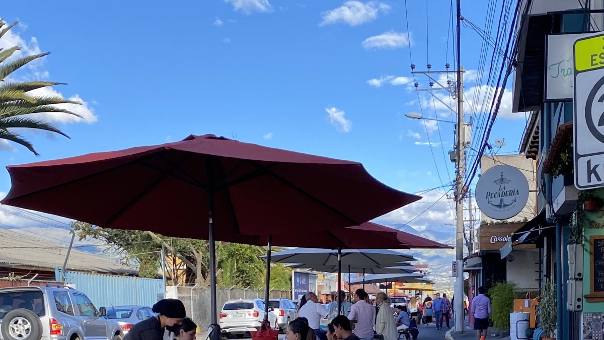 Comensales disfrutan de la gastronomía en mesas al aire libre en esta parroquia de Quito.