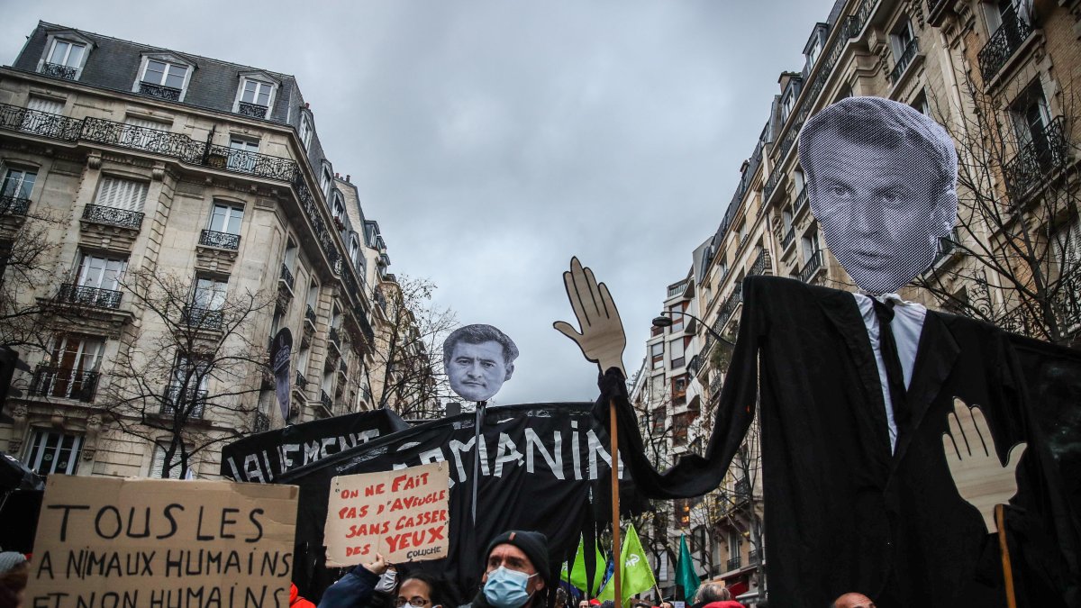 manifestantes levantan efigies del presidente francés Emmanuel Macron (der.), el Ministro del Interior Gerald Darmanin (centro) y el Prefecto de París Didier Lallement (izq.).