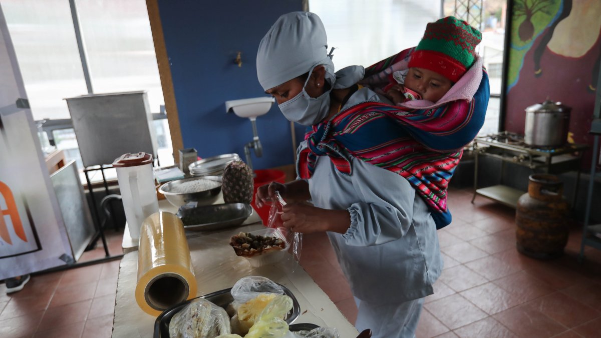 Las mujeres se turnan y se dividen en grupos de seis para preparar las pizzas y atender a los comensales, algunas cargando a sus hijos en aguayos, un colorido textil andino que se amarran a la espalda.