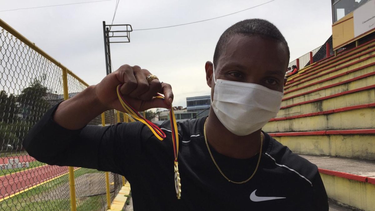 Álex Quiñónez, velocista ecuatoriano, muestra su medalla de oro tres ganar una de las pruebas.