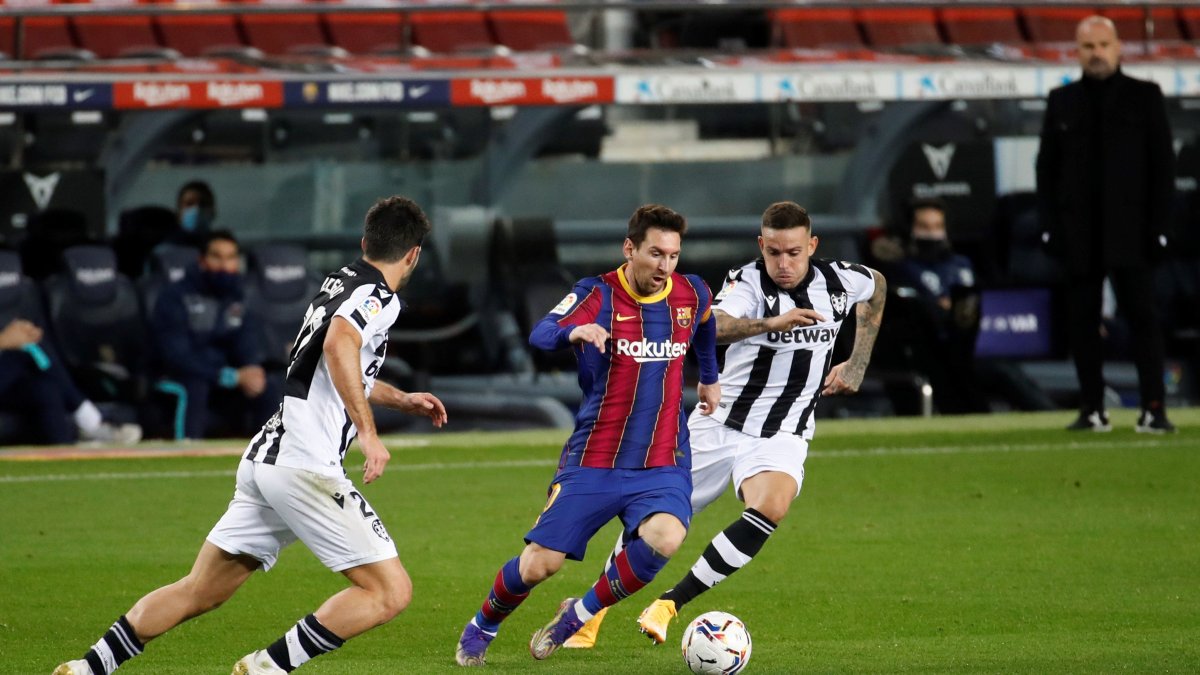 Lionel Messi, ofensivo de Barcelona, intenta eludir la marca de dos rivales del Levante.