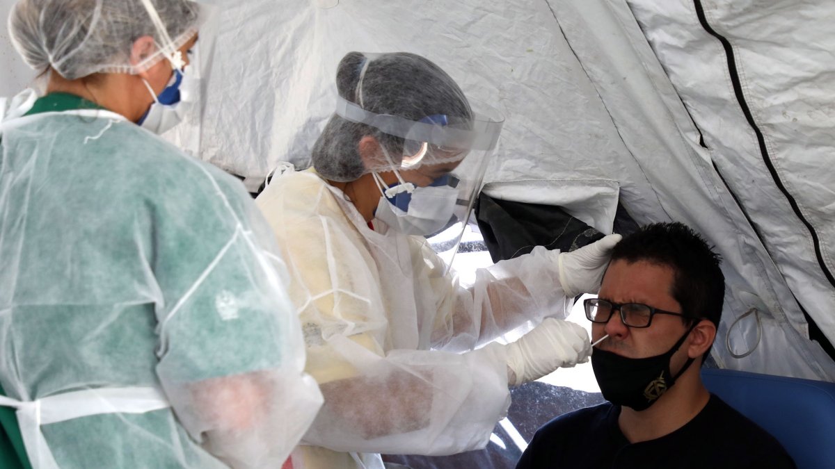 Personal médico le toma la prueba de coronavirus a un hombre en São Gonçalo, estado de Río de Janeiro.