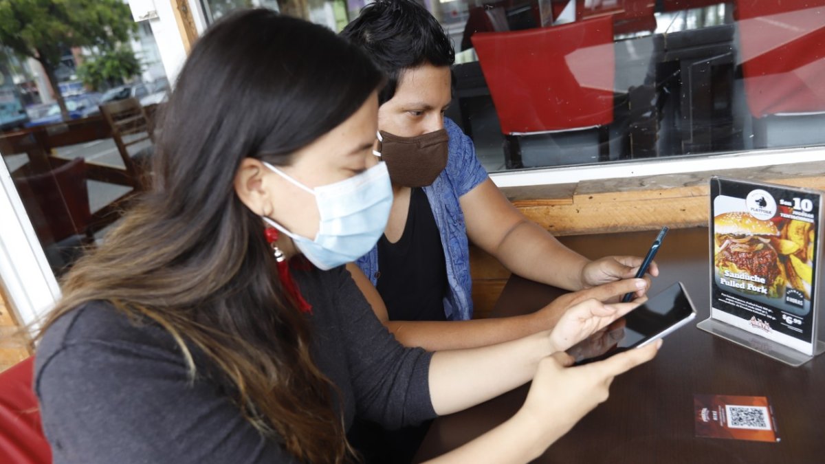 Usuarias de un restaurante en Guayaquil utilizan sus celulares para aceder al menú a través del código QR, eso se hace ahora por bioseguridad.