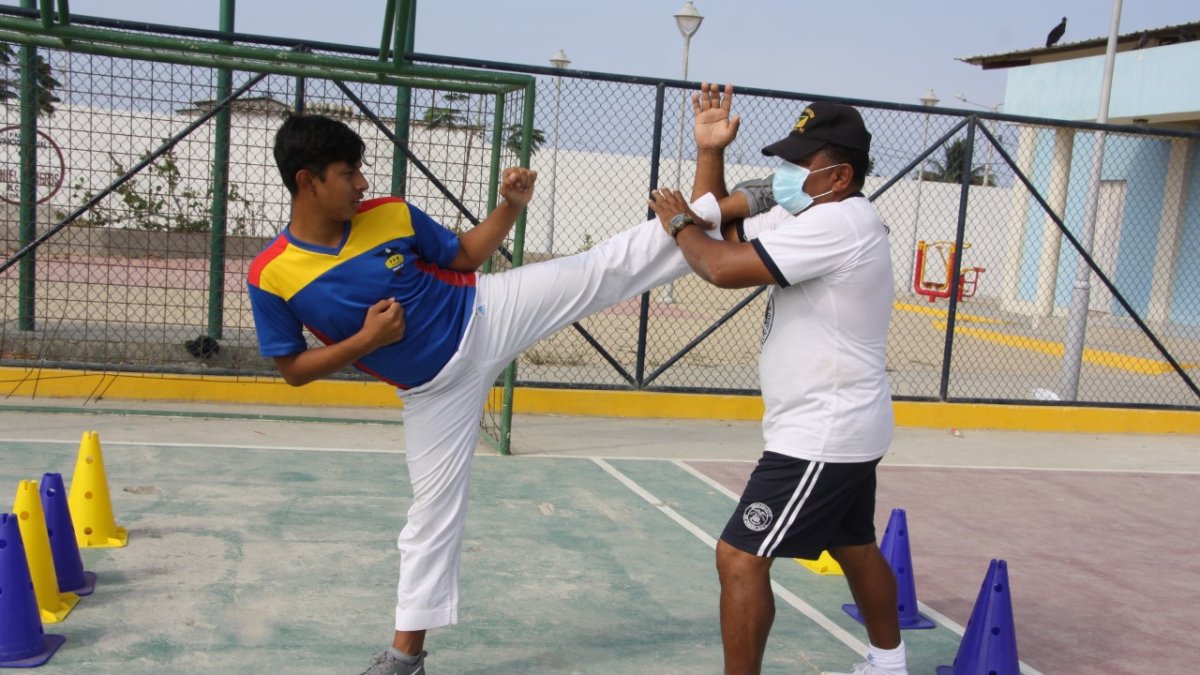 Entrenamientos. Kember Beltrán, junto a su entrenador Jorge Vargas, durante una jornada en la cancha de uso múltiple de su barrio, sitio donde improvisa sus prácticas diarias.