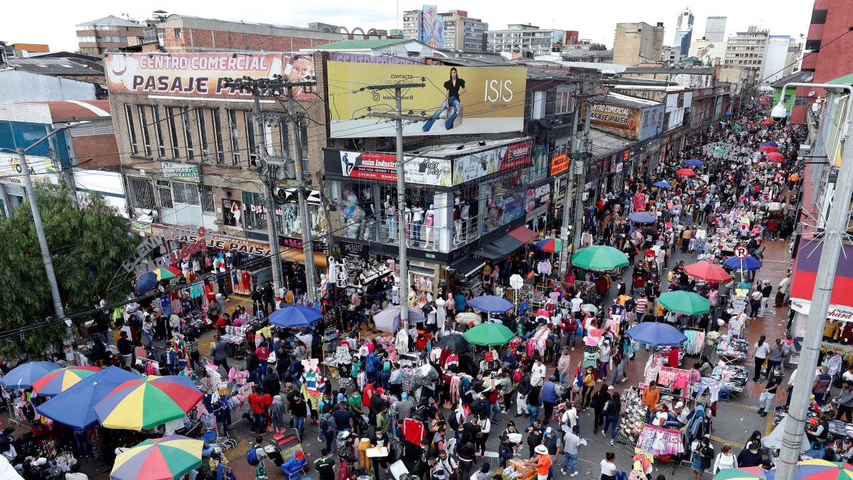 Ciudadanos se aglomeran mientras hacen compras navideñas en el popular sector de San Victorino, en Bogotá (Colombia).