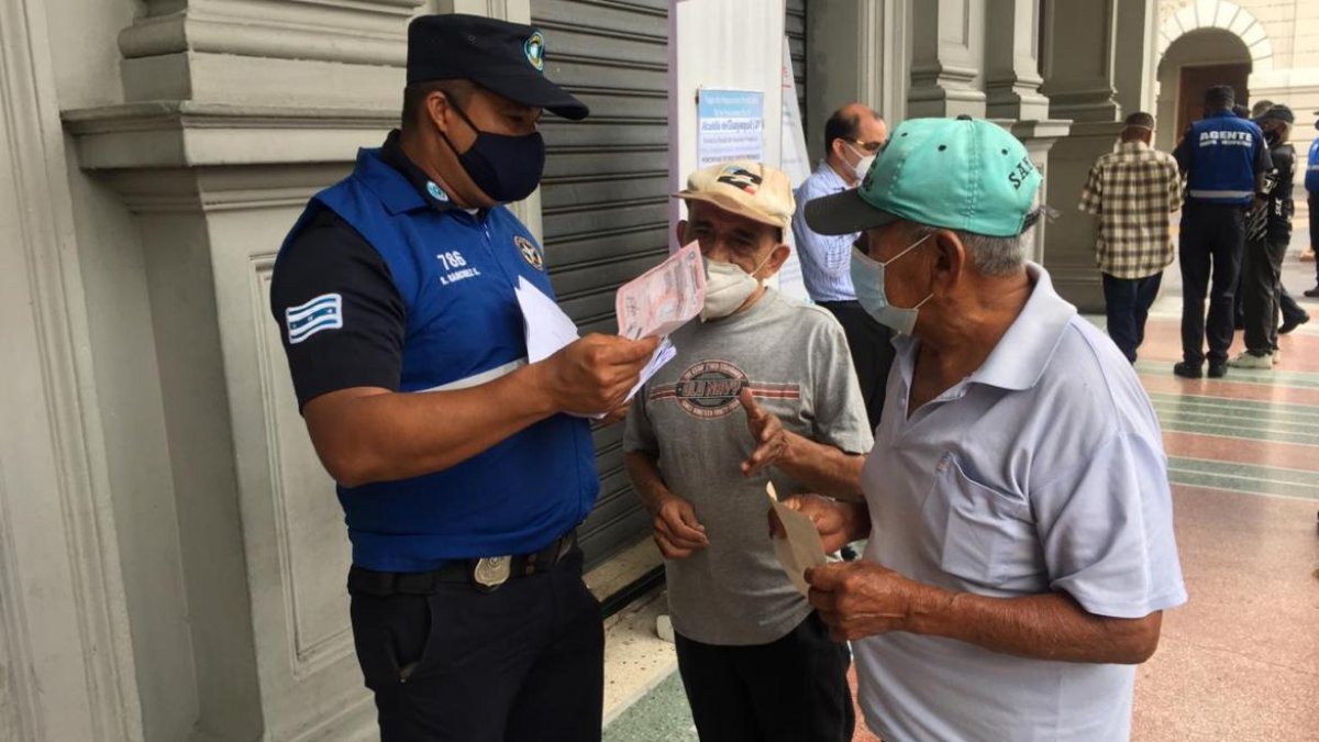 Hecho. Dos adultos mayores eran orientados por un guardia, ayer.