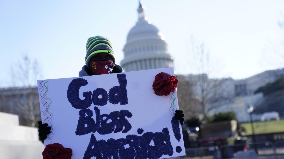 Dios bendiga a América entre los carteles que se puedan leer fuera del Capitolio.