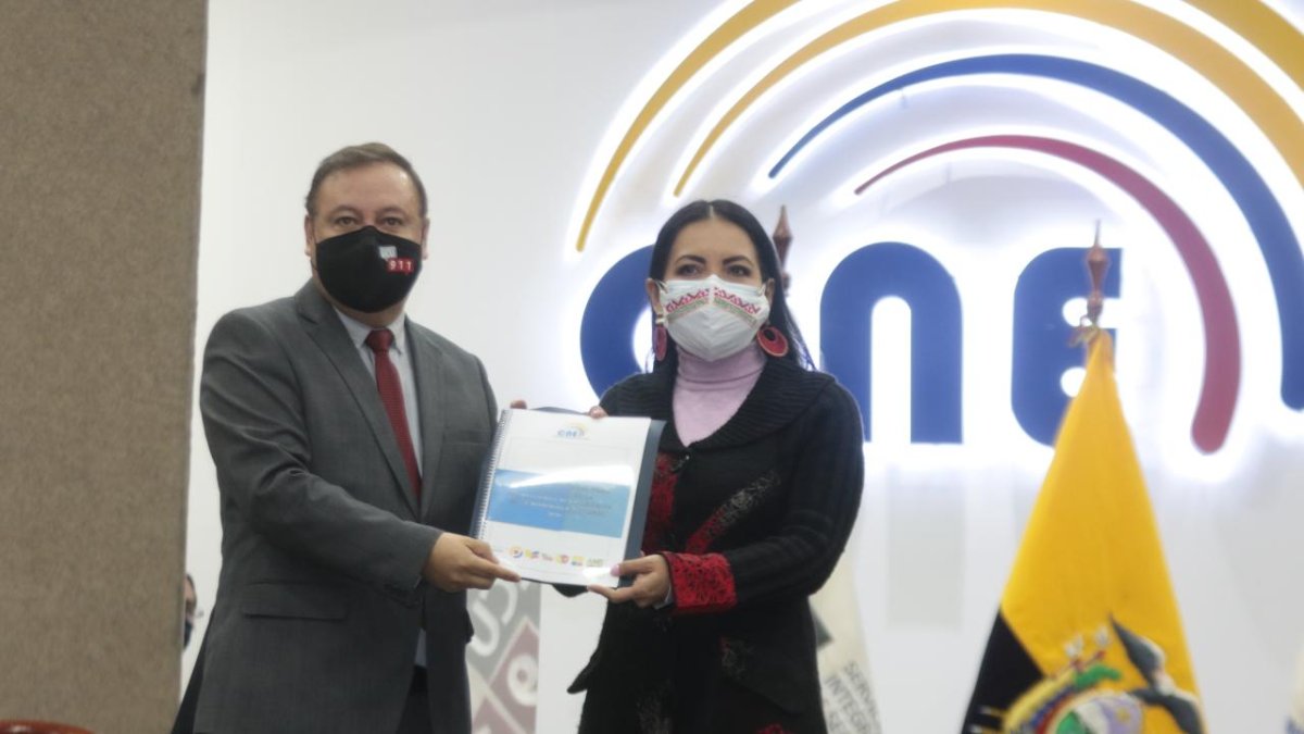 Normativa. El presidente del COE, Juan Zapata, entregó ayer el protocolo a la principal del CNE, Diana Atamaint.