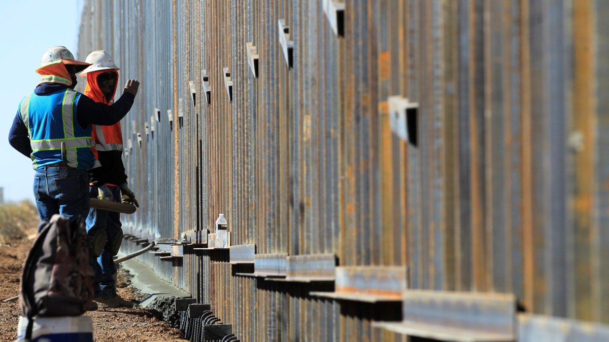 Obreros de la constructora Ultimate Concrete agilizan la terminación del muro metálico ordenado por  Trump, en la frontera con el condado de Columbus, Nuevo México (EE. UU.). 