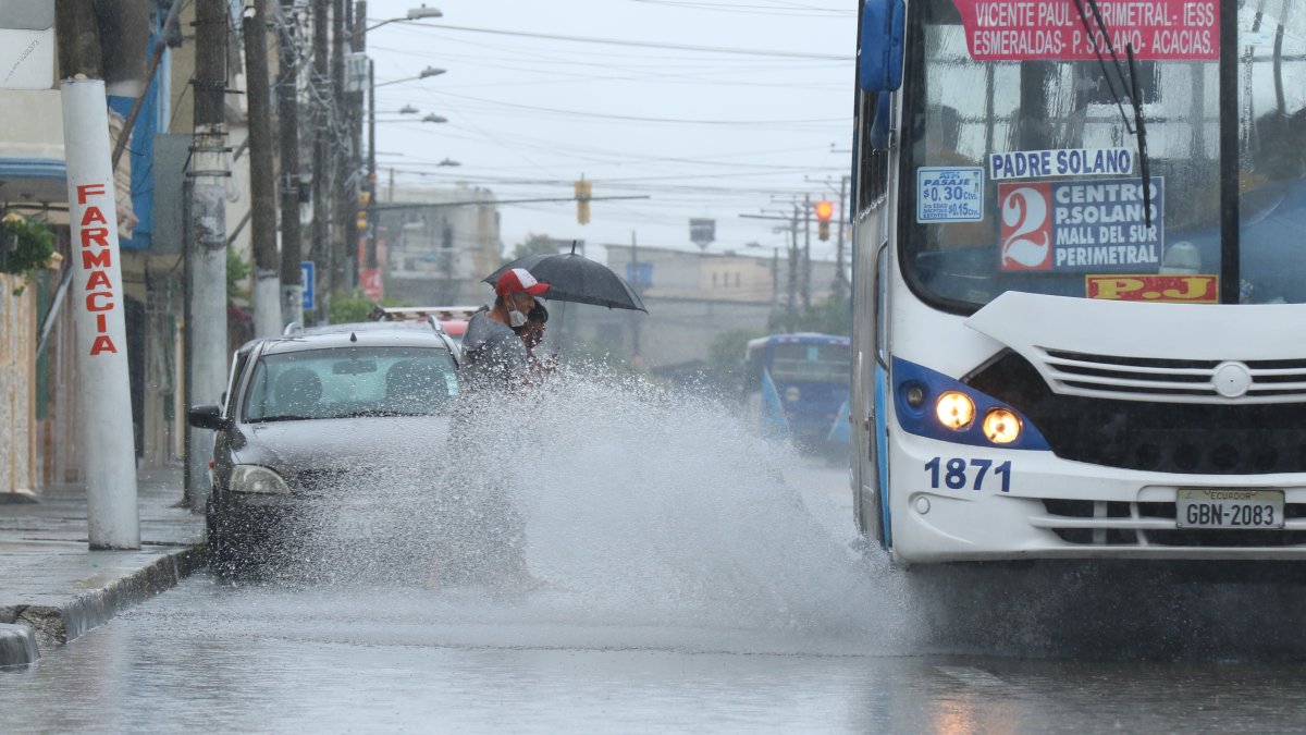 Sur. Dos ciudadanos empapados por el agua que levantó un bus.