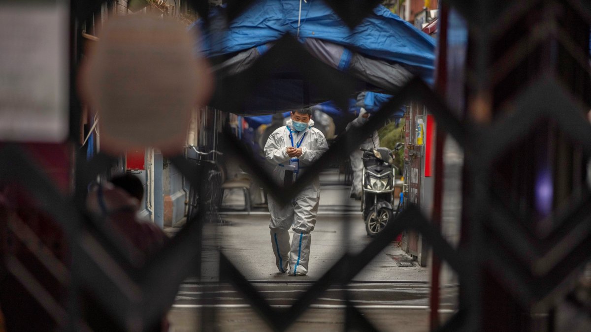 Un trabajador sanitario recorre la urbanización Guixi, que se encuentra confinada tras registrase varios casos de la covid-19, en Shanghái (China) este martes.