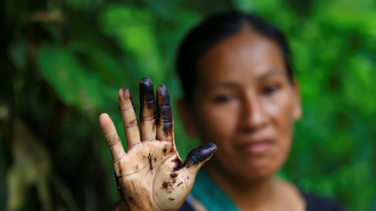 Una indígena de la comunidad de Amarumesa muestra en su mano residuos de petróleo en la Amazonía ecuatoriana.