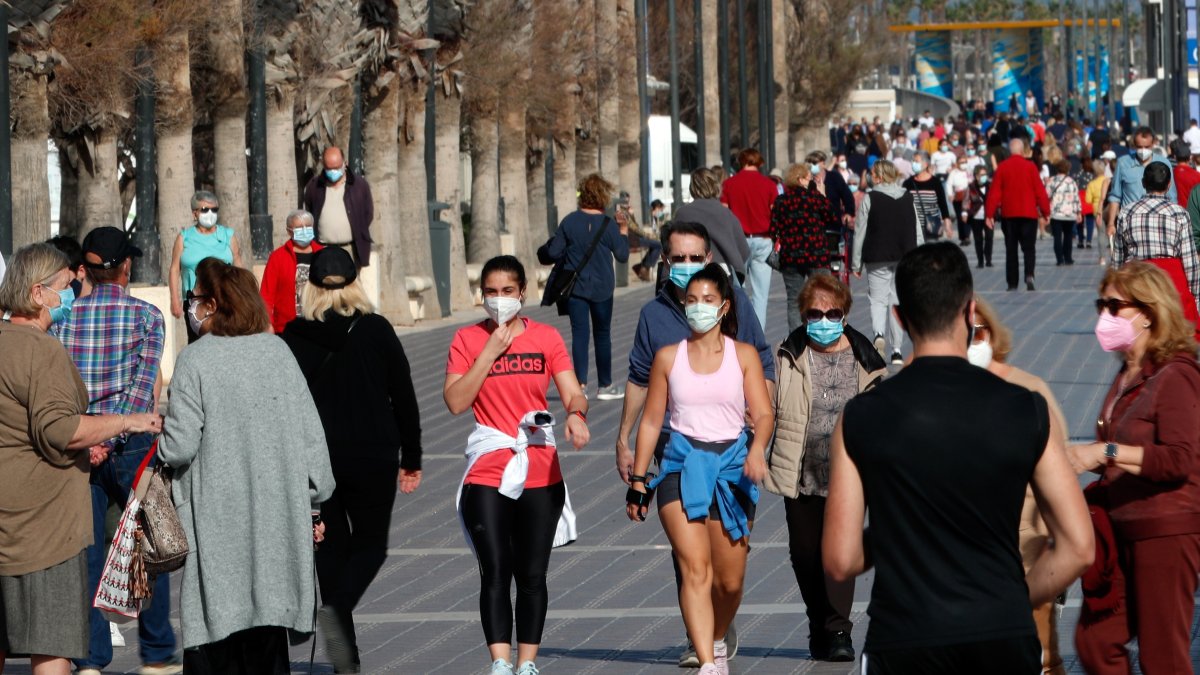 Decenas de personas por el paseo de la playa de la Malvarrosa de Valencia, España.