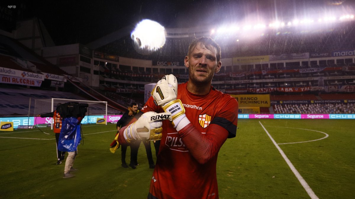 Javier Burrai, arquero de Barcelona, muestra sus guantes con el nombre de su fallecido padre tras ser campeón en el Rodrigo Paz.